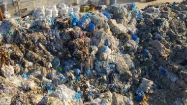 Atık ayıklama tesisinde büyük çöp yığınlarının insansız hava aracı görüntüsü. Yavaş çekim