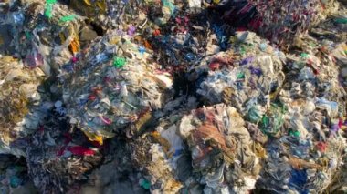 Atık ayıklama tesisinde büyük çöp yığınlarının insansız hava aracı görüntüsü. Yavaş çekim