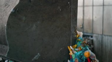 Atık ayıklama tesisinde büyük bir çöp yığınına atık boşaltan bir kazıcı. Yavaş çekim