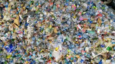 CHISINAU, MOLDOVA - Mart 2023: Atık ayıklama tesisinde büyük bir plastik çöp yığınının insansız hava aracı görüntüsü. Yavaş çekim