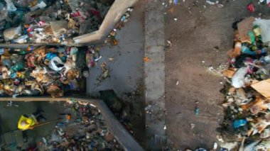 CHISINAU, MOLDOVA - Mart 2023: İşçiler ve bir kazıcı atık tasnif tesisinde bir taşıyıcı bandına çöp yüklüyorlar. Yavaş çekim