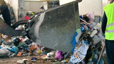 CHISINAU, MOLDOVA - Mart 2023: Çöp ayıklama tesisine çöp boşaltan bir kazıcı. Yavaş çekim