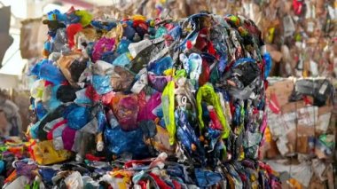 CHISINAU, MOLDOVA - Mart 2023 Atık ayıklama tesisinde sıkıştırılmış plastik çöp küpü. Yavaş çekim