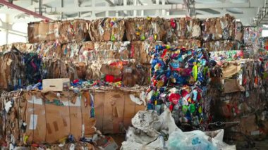 CHISINAU, MOLDOVA - Mart 2023: Atık ayıklama tesisinde sıkıştırılmış kağıt ve plastik çöp yığını. Yavaş çekim