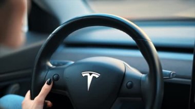 CHISINAU, MOLDOVA - Mart 2023: Tesla Model 3 'ü kullanan bir kadının yakın görüntüsü. Yavaş çekim