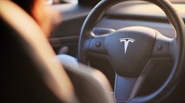CHISINAU, MOLDOVA - Mart 2023: Tesla Model 3 'ü kullanan bir kadının yakın görüntüsü. Yavaş çekim