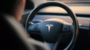 CHISINAU, MOLDOVA - Mart 2023: Tesla Model 3 'ü kullanan bir kadının yakın görüntüsü. Yavaş çekim