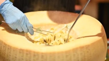 Şef parmesanlı peynirli İtalyan makarnası hazırlıyor.