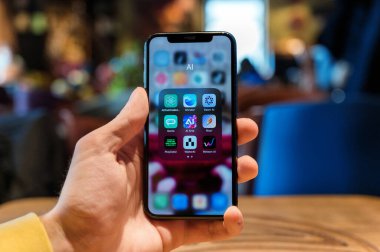 CHISINAU, MOLDOVA - APRIL, 2023: AI tabanlı uygulamalar klasörüyle telefon tutan adam