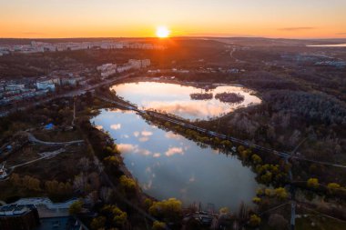 Chisinau 'nun günbatımında Moldova' da hava aracı görüntüsü. Yeşillik, göller ve konut binalarıyla Alunelul Park