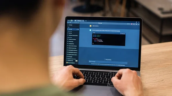 stock image CHISINAU, MOLDOVA - APRIL, 2023: A person making a request in ChatGPT on a laptop to write a clock in C. Chat bot providing an example