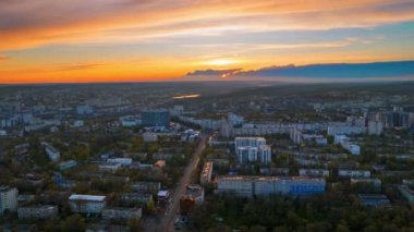 Chisinau 'nun gün batımında Moldova' daki hava aracı görüntüsü. Güneşin üzerinde, birden fazla bina, yeşillik ve arabalı yollar bulunan yerleşim bölgesi.