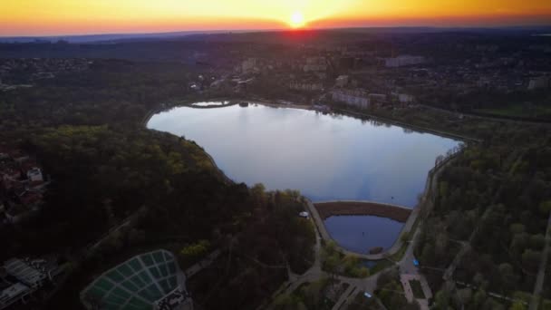 日没でチシナウの空中ドローンビュー モルドバ 湖と緑に囲まれたバレア モリラー パーク — ストック動画