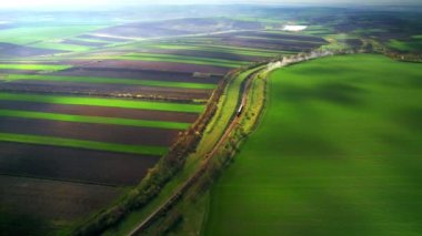 Moldova 'daki doğanın insansız hava aracı görüntüsü. Geniş yeşil tarlalar, hareket eden tren.