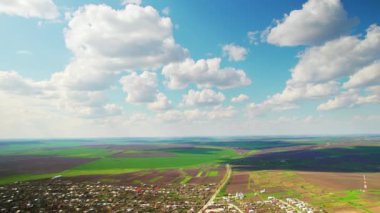 Moldova 'daki bir köyün insansız hava aracı görüntüsü. Birden fazla bina, yeşil alanlar, bulutlu gökyüzü.