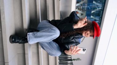 Kırmızı şapkalı genç bir blog yazarı kendini akıllı telefondan kaydediyor.