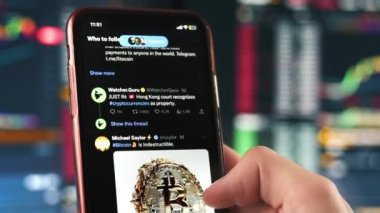 CHISINAU, MOLDOVA - APRIL, 2023: Akıllı telefondan twitter 'ı açan ve görüntüyü kaydırmaya başlayan bir adamın yakın görüntüsü. Diğer uygulamalarla ana ekran