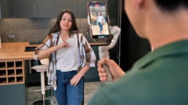 Dans eden genç bir kadın blogcuyu stüdyoda bir dengeleyicide akıllı telefondan etkileyen bir kişi.