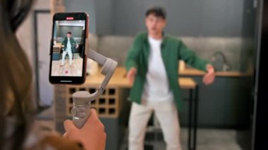 Dans eden genç bir blogcuyu kaydeden kişi akıllı telefondan bir stüdyoda dengeleyiciye nüfuz ediyor.