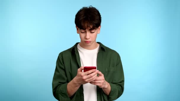 Young Man Using His Phone Showing Emotion Reflection Blue Background — Stock Video