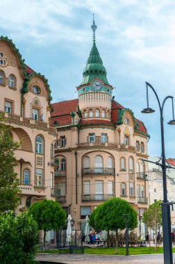 ORADEA, ROMANIA - Mayıs 2023: şehir merkezindeki Unirii Meydanı 'ndaki Kara Şahin Sarayı manzarası. Yeşiller