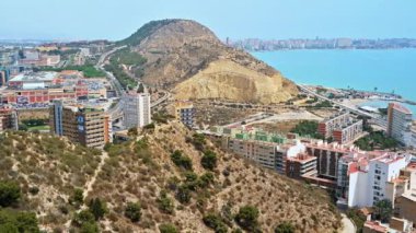 İspanya, Alicante 'de deniz kıyısında bir dağ ve şehir manzarası