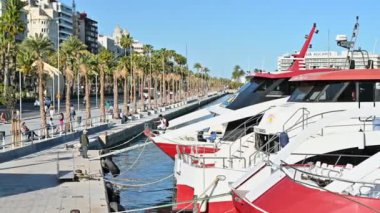 ALICANTE, İSPAN - 2023 Nisan: limandaki iskeleye bağlı yatlar. Arka planda yürüyen insanlar