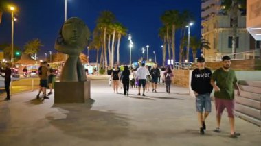 ALICANTE, İSPAN - 2023: Falcı Heykeli 'nin yakınındaki sokakta yürüyen insanları gece görüşü