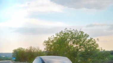 CHISINAU, MOLDOVA - MAYIS, 2023: Otoyoldaki hareketli siyah Tesla Model 3 'ün arkası. Arka planda doğa var. Yavaş çekim
