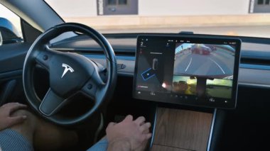 CHISINAU, MOLDOVA - Mayıs 2023: Otomatik pilotta bir Tesla Model 3 'ün iç görüntüsü. Şoför direksiyona dokunmuyor.