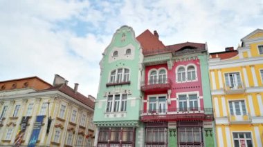 Romanya 'nın Timisoara kentindeki Unirii Meydanı' nda bulunan renkli cepheli Bruck Evi manzarası