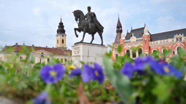 Romanya 'nın başkenti Oradea' daki Unirii Meydanı 'nda bulunan Kral 1. Ferdinand heykeli görülüyor. Önplanda çiçekler