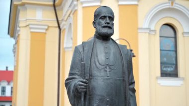 Romanya 'nın Oradea kentindeki Aziz Nicholas Katedrali' nin arka planında Demetriu Radu heykeli