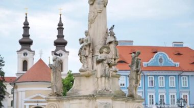 TIMISOARA, ROMANIA - 22 Mayıs 2023: Unirii Meydanı 'ndaki Veba Sütununun Manzarası. Arka planda dinlenen ve yürüyen insanlar var.