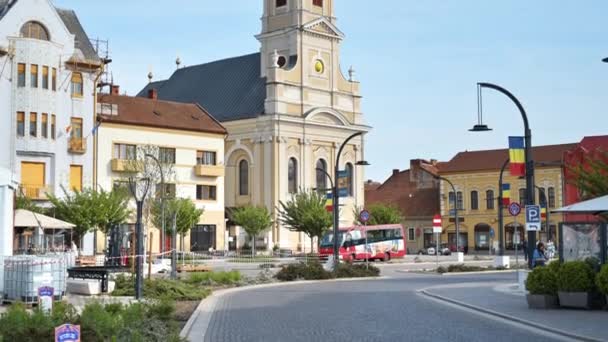 ルーマニアのダウンタウンのOradeaのUnirii SquareにあるMoon Churchの眺め 広場の前に人がいる — ストック動画