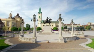 Romanya 'nın Oradea kentindeki Unirii Meydanı' nın insansız hava aracı görüntüsü. Kral I. Ferdinand heykeli, Aziz Ladislaus Kilisesi ve belediye binası, yürüyen insanlar.