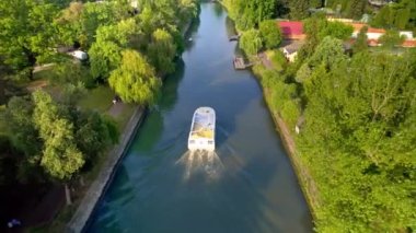 TIMISOARA, ROMANIA - MAYIS, 2023: Nehrin her iki yakasında yüzen tekne ve yeşillikle Bega Nehri 'nin insansız hava aracı görüntüsü