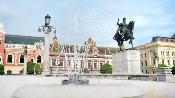フェルディナンド1世像やその他の歴史的建造物 ルーマニアのオラデアの前景にある噴水のあるユニリイ広場の眺め スローモーション — ストック動画