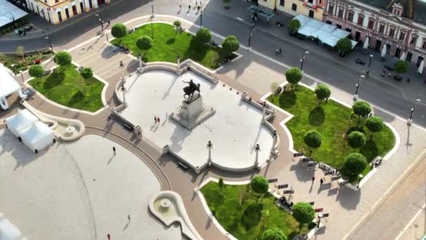 ルーマニアのダウンタウンにあるUnirii Squareの実際のドローンビュー フェルディナンド1世像と人々の歩き方 — ストック動画