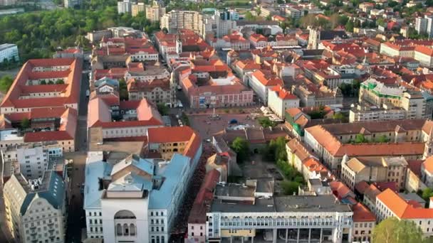 ルーマニアの日没時のティミソアラの空中ドローンビュー 街のダウンタウン 人々との自由広場や周りの複数の歴史的建造物の眺め — ストック動画