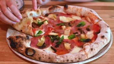 İtalyan restoranında pizza yiyen bir kadın.