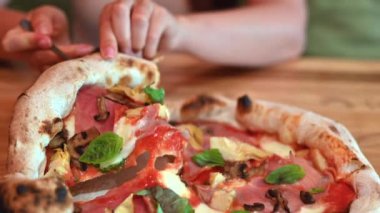 İtalyan restoranında pizza yiyen bir kadın.