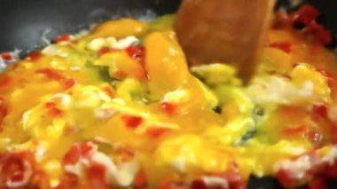 Siyah bir tavada omlet hazırlama, çiğ yumurta düşmesi, ağır çekim.
