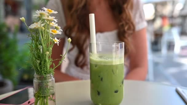 在餐厅的阳台上喝绿茶的女人 — 图库视频影像