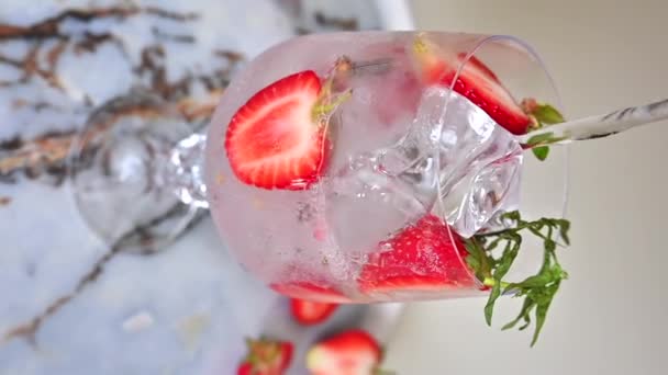 矿泉水倒入装有冰块和草莓鸡尾酒的杯子中 动作缓慢 — 图库视频影像