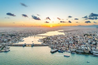 Türkiye 'de gün batımında İstanbul' un hava aracı görüntüsü. Altın Boynuz su yolu üzerinde yüzen gemileri olan çok sayıda bina, cami, Galata ve Metro köprüsü.