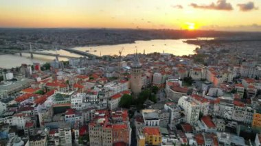 Türkiye 'de gün batımında İstanbul' un hava aracı görüntüsü. Galata Kulesi 'nin etrafındaki birçok yerleşim yeri, arka plandaki Golden Horn su yolu.