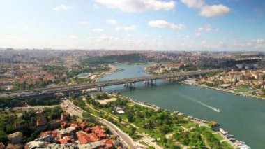 İstanbul, Türkiye 'nin insansız hava aracı görüntüsü. Halic Köprüsü 'nde birden fazla hareket eden araba, Golden Horn su yolunun her iki tarafında birden fazla konut binaları, yüzen tekne, yeşillik