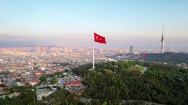 Türkiye 'de gün batımında İstanbul' un hava aracı görüntüsü. Ulusal bayrakları, yeşilliği ve arka planında şehir manzarası olan Camlica Tepesi