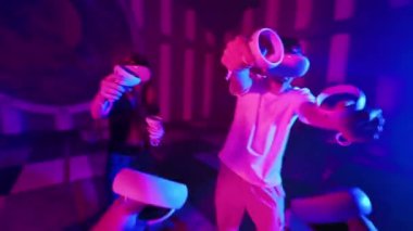 Sanal gerçeklik VR ekipmanlarını arenada ilk kullanan kişi. Sanal oyunlar oynayan bir grup genç arkadaş. Neon ışıkları